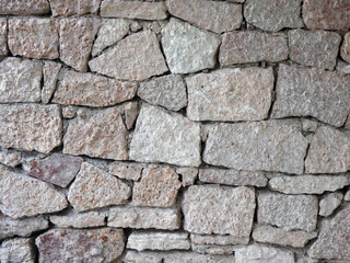 Fragment of a wall lined with stone slabs of a light beige shade
