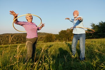 woman man outdoor senior couple happy retirement together smiling love spinning hoop exercise mature