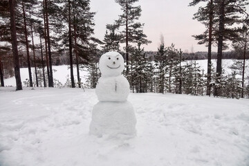 Funny snowman in the snow-covered forest