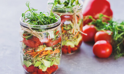 Vegetables salad in open jar Tomato, avocado,pepper, cucumber, micro greens Healthy food, diet, clean food and vegetarian concept