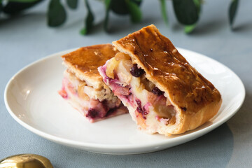 Strudel with apples, currants and cinnamon. Sweet austrian strudel on plate. Baked dessert with fruit filling.