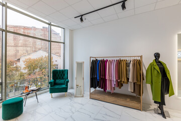 Interior of a clothing store in a modern style with glass stained glass and clothes on a hanger