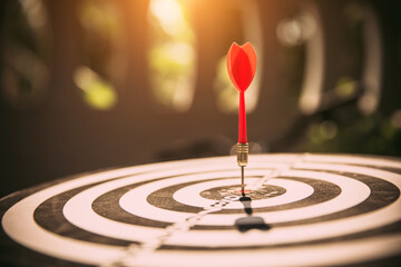 Close-up the bullseye or bulls eye target or dart board has dart arrow throw hitting the center of...