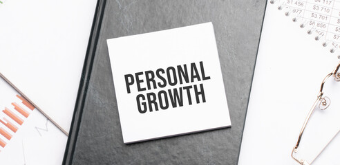 Notepad with text PERSONAL GROWTH on a charts and numbers. Business concept.