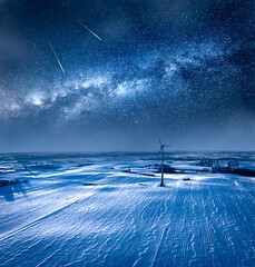 Milky way over wind turbine in winter. Alternative energy, Poland.