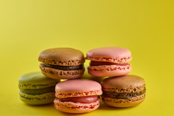Fototapeta premium Cake macaron close up on yellow background flavor almond cookies pastel colors.