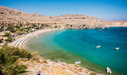Beautiful beach of Lindos, white Village in Rhodes, Greece. Bay with clear blue water