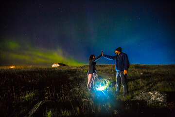 Fototapeta na wymiar Reykjanes Skaginn, Iceland »; August 2017: A couple of tourists on the Reykjanes peninsula under the northern lights.