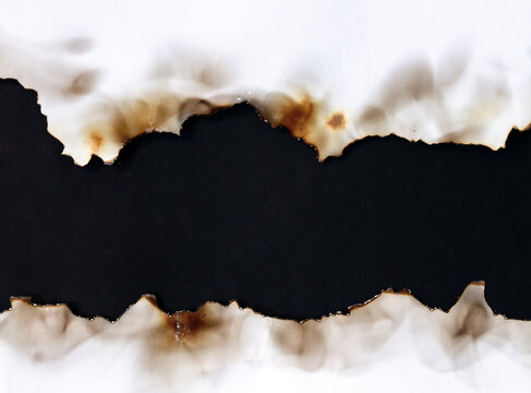 Burnt old torn white paper on black background