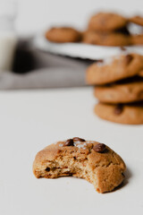  Chocolate chip Cookies on white table concept shot with milk, green cactus grey napkin