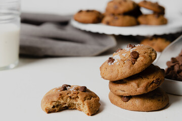  Chocolate chip Cookies on white table concept shot with milk, green cactus grey napkin