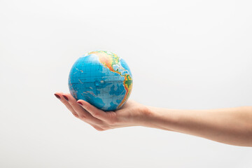Small globe in a female hand. World in human hands