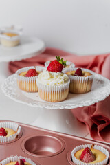 Muffins Cupcake cream decorated with colorful sprinkles on white background and strawberries 
