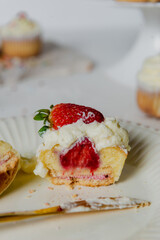 Muffins Cupcake cream decorated with colorful sprinkles on white background and strawberries 