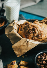  Chocolate chip Cookies on white table concept shot with milk, green cactus grey napkin