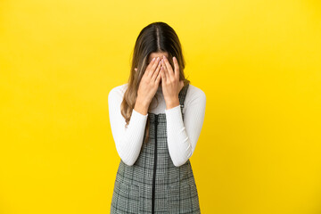 Young caucasian woman isolated on yellow background with tired and sick expression