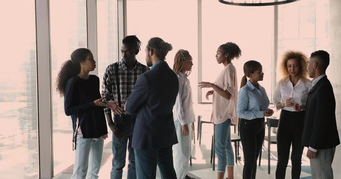 African employees corporate staff members having conversation diverse businesspeople split into groups talking at break in office boardroom. Business communication, work relations, workforce concept