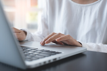 Close up of woman hands searching the internet on laptop computer