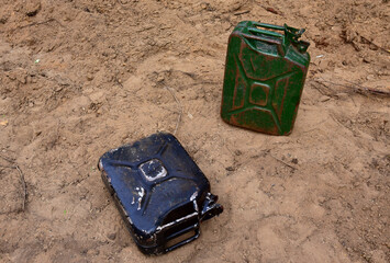Canister for gasoline on the sand. The discarded empty canister lies on the ground. Environmental...