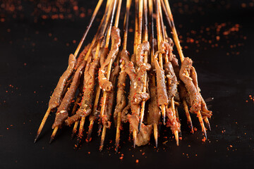  Kebab. Grilled chicken intestine with spices on black background