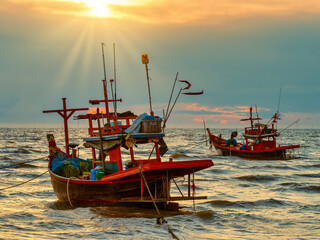 The small fishing boats are anchoring at the gulf under the sunset.
