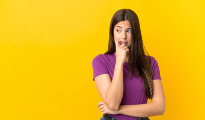 Teenager Brazilian girl over isolated yellow background nervous and scared