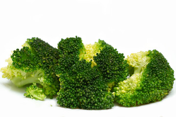 Cooked ripe broccoli inflorescences with olive oil isolated on white background.