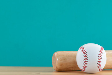 Close up baseball and baseball bat on wooden table with green copy space background, sport concept