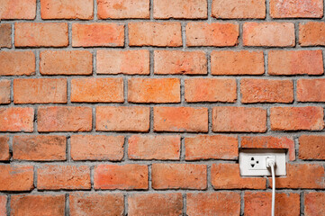 abstract orange brick wall with power plug texture background  