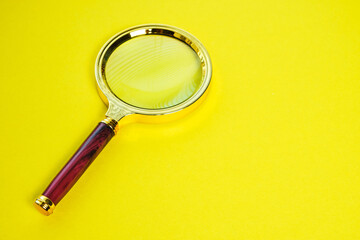 Magnifying glass on a bright yellow background.