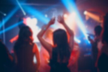 Silhouettes of a crowd on show in night club celebration. Blurred, bokeh, background, restaurant.