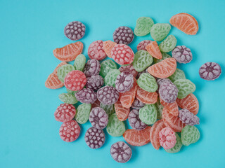 Sweet fruit caramels on a colored background. Top view of a colorful assortment of caramels. Selective focus