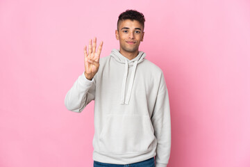 Fototapeta premium Young Brazilian man isolated on pink background happy and counting four with fingers