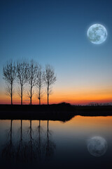 fantastic sunset over the river with reflected full moon