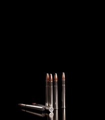 Bullet isolated on black background with reflexion. Rifle bullets close-up on black back....
