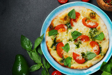 italian bread focaccia with tomatoes, basil and sea salt on dark concrete bakground, top view