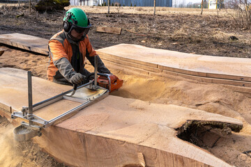 A man cuts boards using a mobile chainsaw mill.