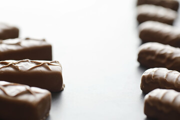 Chocolate bars on a black background in backlight. Chocolate with filling. Sweet sweets for snack and tea.