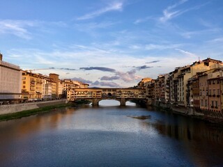 Fototapeta premium Sunset with the golden bridge view in Florence. Italy. Ponte Vecchio. Famous sightseeing in Firenze. Arno river.