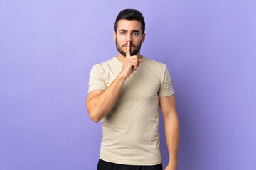 Fototapeta premium Young handsome man with beard over isolated background showing a sign of silence gesture putting finger in mouth