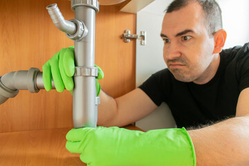 Drain Problems, blockage plumbing kitchen sink pipe unclog plunger man hand hold