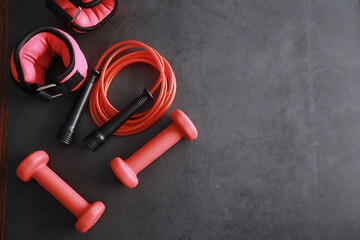 Sport and healthy lifestyle. Accessories for sports. Yoga mat dumbbell and jump rope. Sports background home exercises concept.