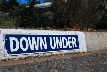 Obraz premium down under sign on a curb stone, Australia