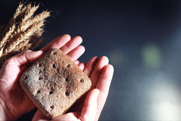 Fresh loaves of bread with wheat and gluten on a black table. Bakery and grocery concept. Fresh,...