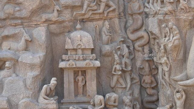 Bas relief rock cut sculptures of Elephant and human are carved in the monolithic granite rocks in Mahabalipuram, Tamil nadu. Ancient historical Indian rock art relief sculptures in large stone panel.