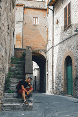 A man sitting on the steps. Tourist. Narni (Terni, Umbria, Italy), medieval city: a typical old...