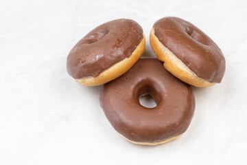 Three Chocolate donuts on the table with copy space