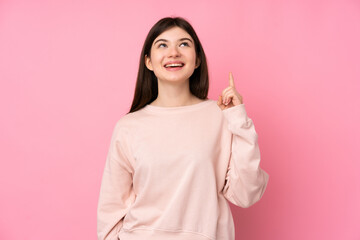 Young Ukrainian teenager girl over isolated pink background pointing up and surprised