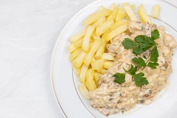 Chicken stew with muschrooms and french fries