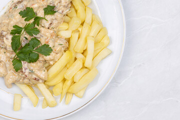 Chicken stew with muschrooms and french fries